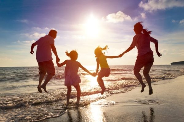 Family jumping up and down on beach together