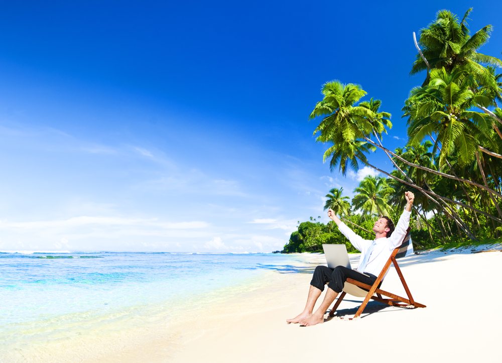 Corporate worker enjoying working on beach at Brisbane