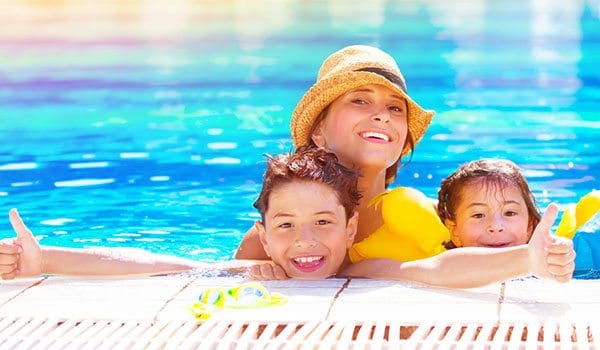 Mum and kids happy in a holiday village swimming pool