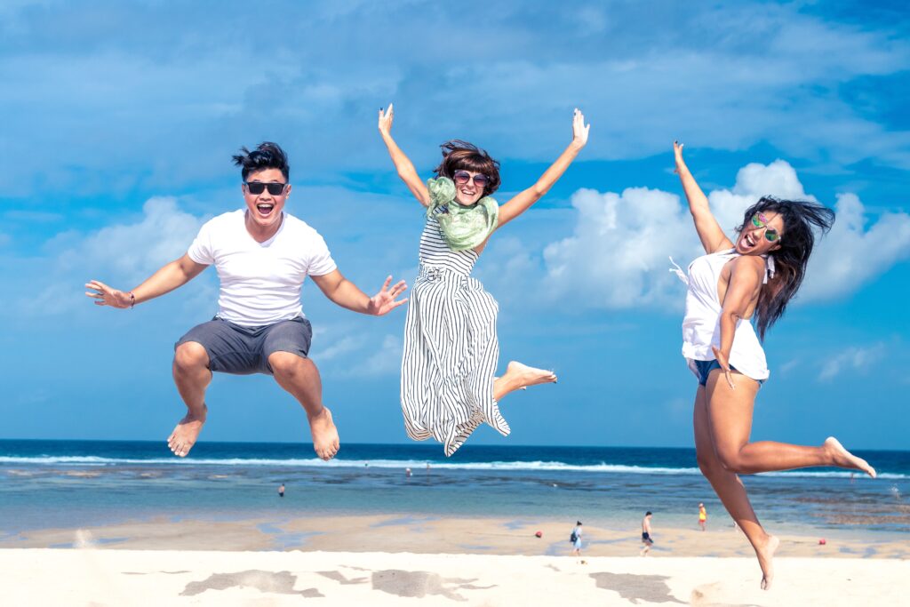 Three friends jumping for joy on the beach