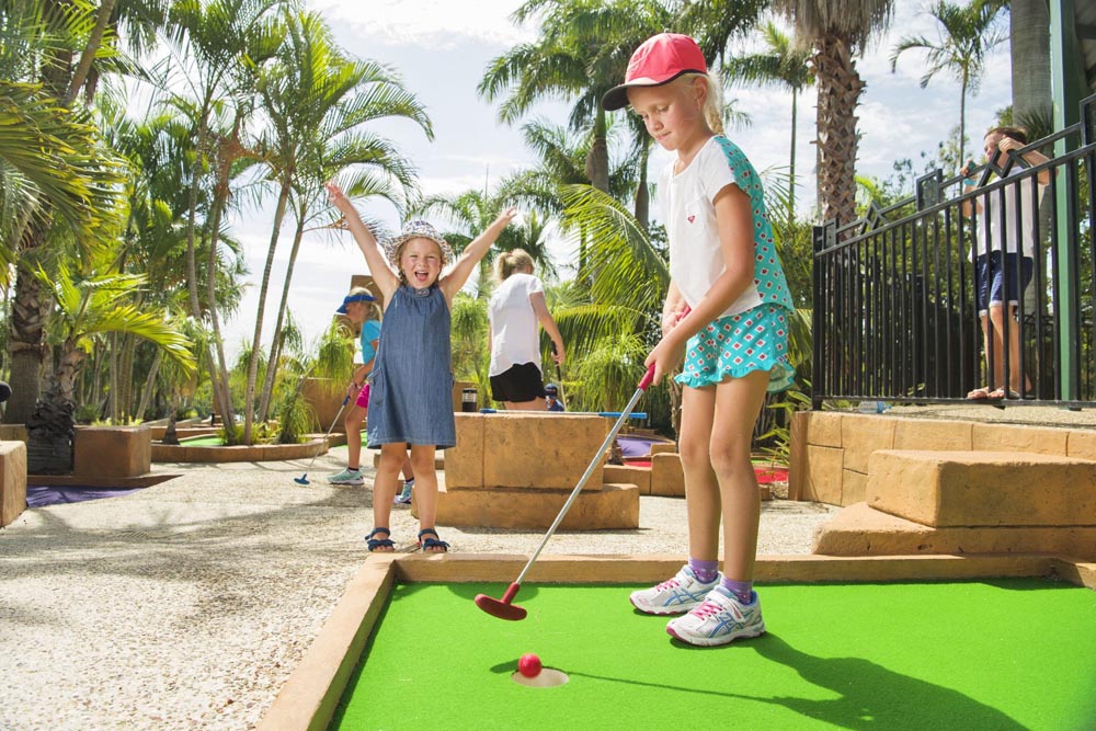 Two young girls playing mini-golf at Brisbane Holiday Village