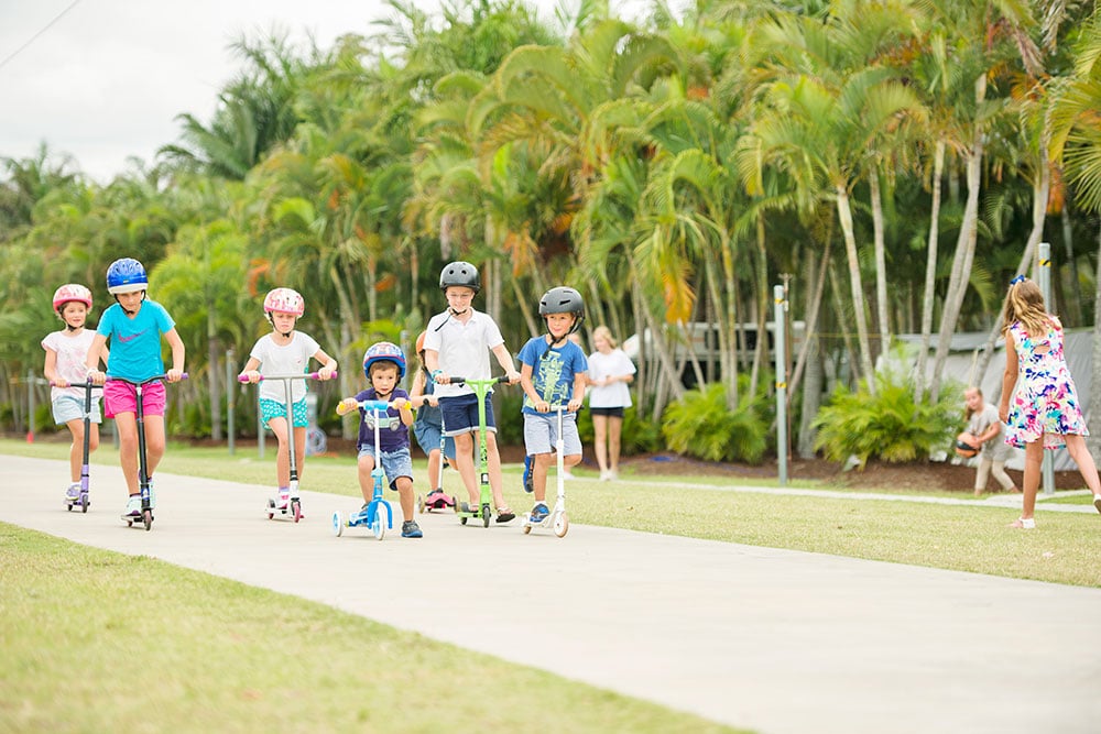 Large group of children riding scooters and bikes on the 350m Bike Track at Brisbane Holiday Village