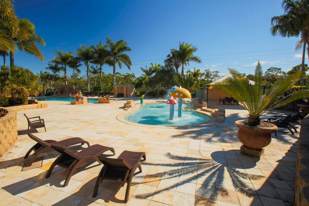 Lagoon area with pool lounges and kiddie pool with fountains at Brisbane Holiday Village