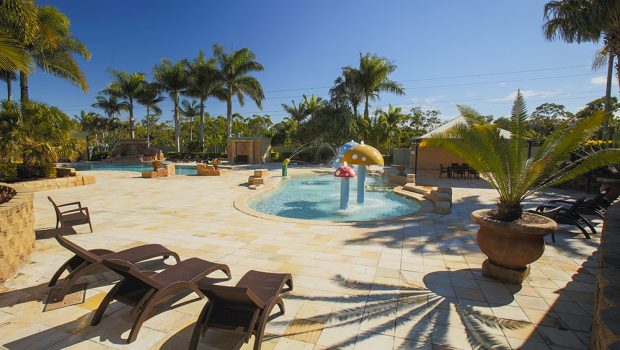 Lagoon area with pool lounges and kiddie pool with fountains at Brisbane Holiday Village